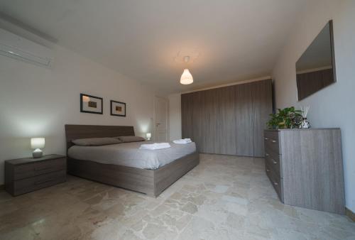 a bedroom with a bed and a dresser at [Attico Dogliani] vista Langhe in Dogliani