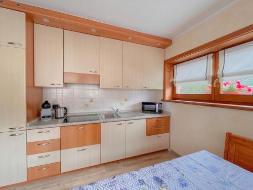 a kitchen with white cabinets and a window at Skyrim Apartment - City Centre in Livigno