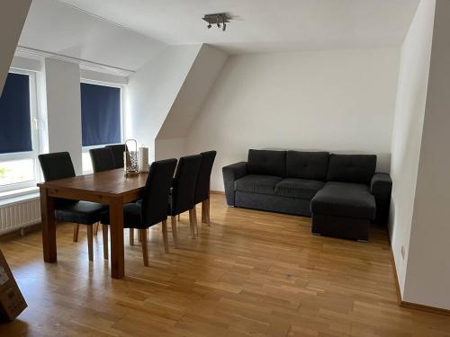 a living room with a table and a couch at Großes Apartment im DG in Leipzig