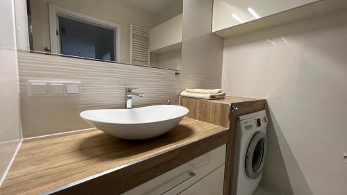 a bathroom with a white bowl sink on a counter at Apartament Kompozytorów Polskich z siłownią in Lublin