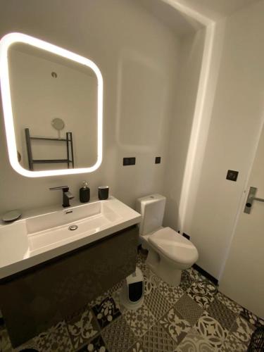 une salle de bain avec un lavabo, des toilettes et un miroir dans l'établissement Elsa & David, à Collioure