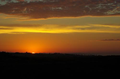 a sunset with the sun setting in the distance at The Third Dolphin in Herolds Bay