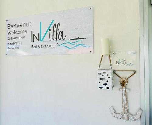 a sign on a white wall with a sign on it at InVilla Bed&Breakfast - Quality Rooms in Santa Maria di Castellabate