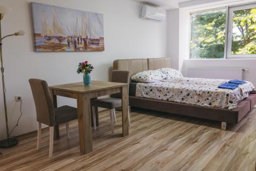 1 dormitorio con mesa, cama, mesa y sillas en RIVERVIEW, en Niš