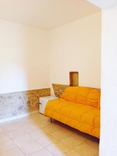 a bedroom with a bed with an orange blanket at Borgo de' Muracci in Ribolla
