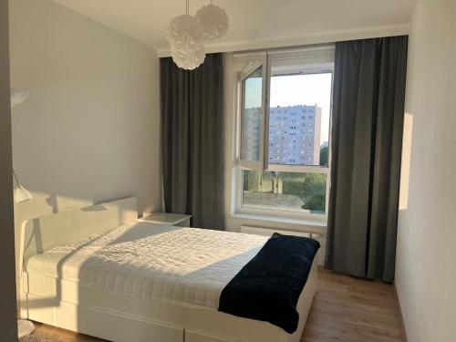 a bedroom with a white bed and a window at Apartament Kompozytorów Polskich z siłownią in Lublin
