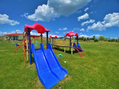 a playground with a slide in a field at Geghama Garden House - Resort Sevan in Sevan