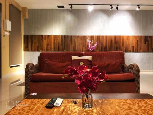 a living room with a couch and a table with flowers at Malacca City Center Town House by 360HOME in Melaka