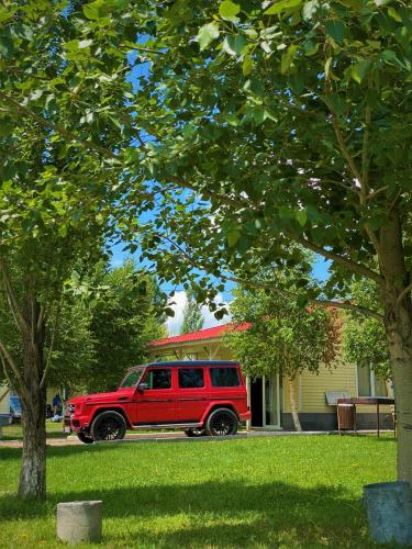 a red jeep parked in front of a house at Geghama Garden House - Resort Sevan in Sevan