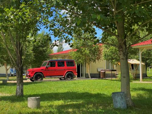 a red jeep parked in front of a house at Geghama Garden House - Resort Sevan in Sevan