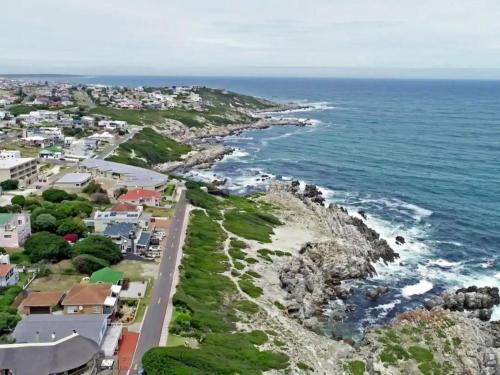 an aerial view of a beach with houses and the ocean at Self Catering Apartment - De Kelders in De Kelders