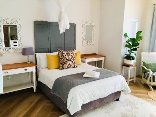 um quarto com uma cama grande e almofadas amarelas em Self Catering Apartment - De Kelders em De Kelders