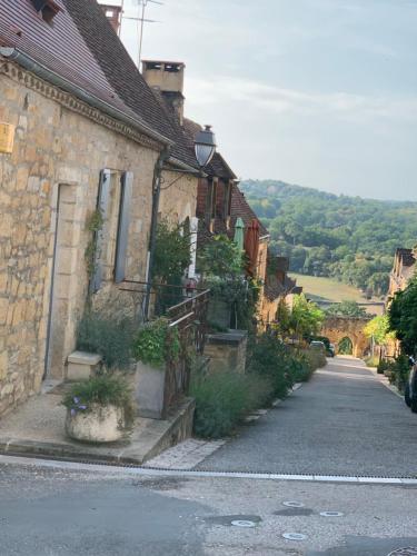 an old stone house on a street next to a road at Maison de la Combe in Domme