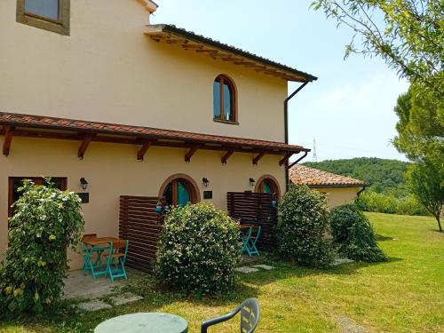 a house with a table and chairs in the yard at Borgo de' Muracci in Ribolla
