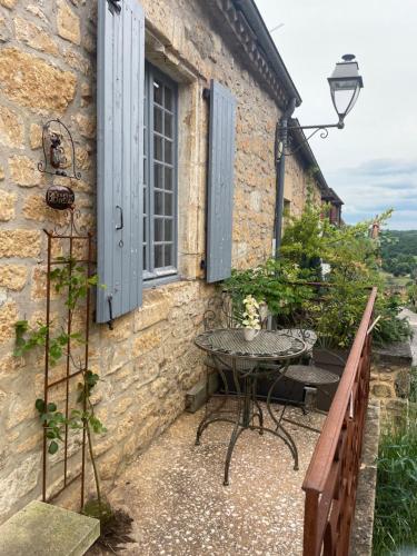 a patio with a table and a window at Maison de la Combe in Domme