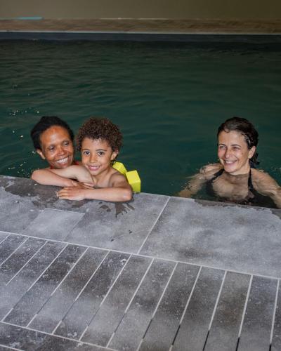 three people in the water in a swimming pool at Domaine de La Soudelle in Chanceaux-sur-Choisille