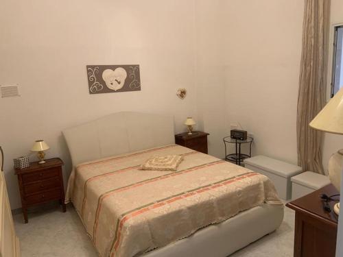 una camera con un letto e due tavoli e una lampada di La casa di Rosa a San Donaci