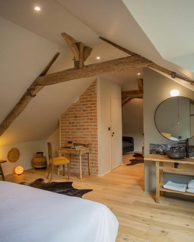 a bedroom with a bed and a table and a brick wall at Domaine de La Soudelle in Chanceaux-sur-Choisille