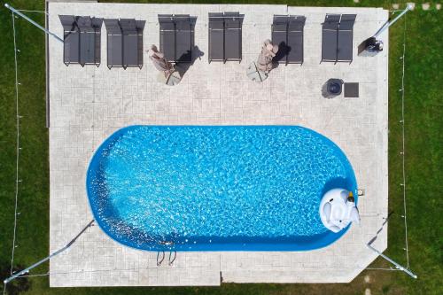 una vista aérea de una piscina con 2 personas sentadas en sillas de césped en Seagloo Glamping - Adults Only en Costinesti