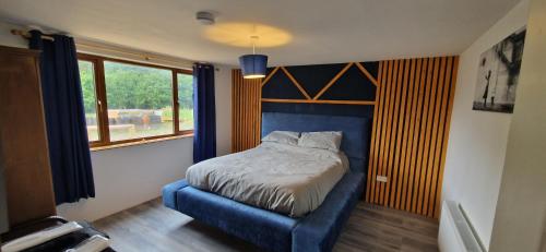 a bedroom with a bed with a blue frame and a window at MT. Leinster View Cabin in Enniscorthy