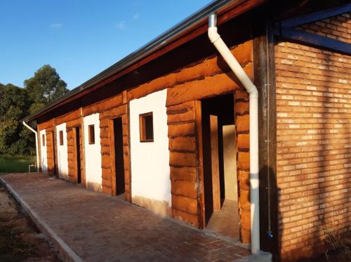a wooden building with doors and a porch at Hospedagem Pé de Serra in Botucatu