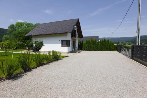 a white house with a black roof and a driveway at Villa Sara on river Una in Bihać