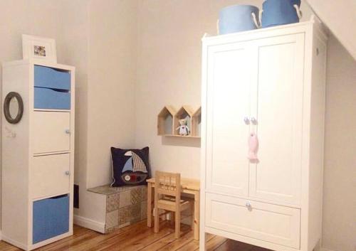 Deichhaus No.5 في بوسوم: غرفة مع خزانة بيضاء مع الأطباق الزرقاء في الأعلى