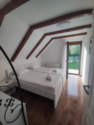 a bedroom with a white bed and a window at Villa Sara on river Una in Bihać