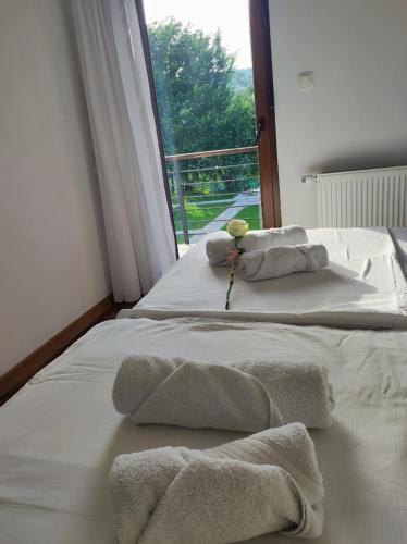 two beds with towels on them in a room with a window at Villa Sara on river Una in Bihać