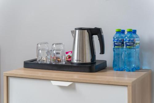 a coffee maker and glasses on a table with water bottles at Stawa Villa & Apart in Świnoujście