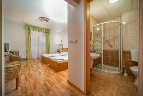 y baño con cama, ducha y lavabo. en Nefelejcs Hotel en Mezőkövesd