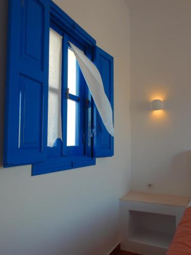 a blue cabinet with a window in a room at Aegeo Hotel in Chora Folegandros
