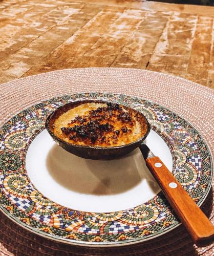 a pie on a plate on a table with a knife at Pousada Vila do Alto in Japaratinga