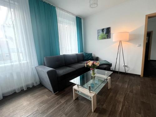 a living room with a couch and a glass table at Ferienwohnungen an der Weser in Bremerhaven