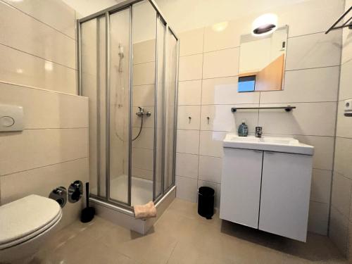 a bathroom with a shower and a toilet and a sink at Ferienwohnungen an der Weser in Bremerhaven