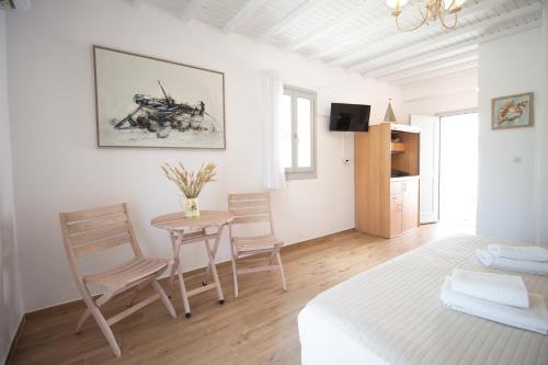 um quarto branco com uma mesa, cadeiras e uma cama em Crystal View Mykonos em Míconos