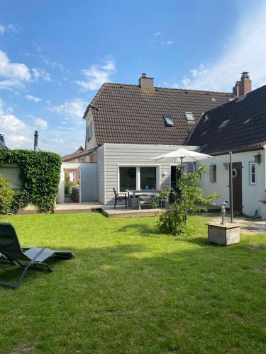 un patio con una casa con una mesa y un patio en Deichhaus No.5 en Büsum