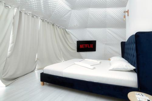 a bedroom with a bed with a netflix sign on it at Seagloo Glamping - Adults Only in Costinesti