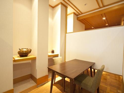 a dining room with a wooden table and chairs at Kannawa Onsen Zekkei no Yado Sakuratei - Vacation STAY 50727v in Beppu