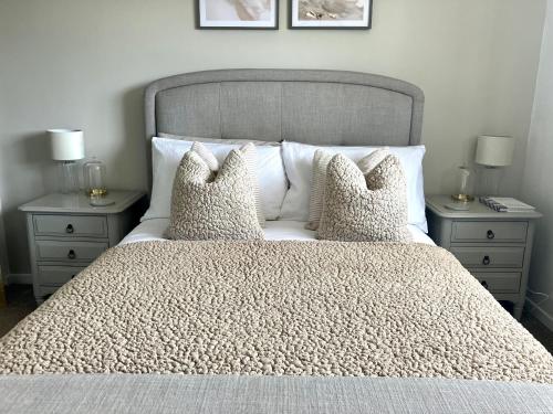 sypialnia z łóżkiem z poduszkami i 2 szafkami nocnymi w obiekcie Central, Cosy Home with Large Garden & Parking, Bournemouth w Bournemouth