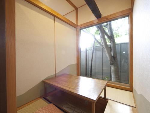 別府市にあるKannawa Onsen Zekkei no Yado Sakuratei - Vacation STAY 50724vの木製テーブルと窓が備わる客室です。
