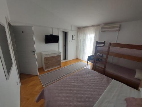 - une chambre avec un lit, une commode et une télévision dans l'établissement Diana Rooms and Apartments, à Starigrad-Paklenica