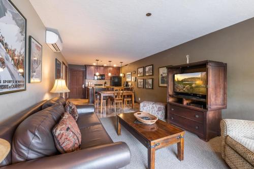 a living room with a leather couch and a television at Treasure Mountain Inn in Park City