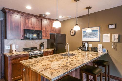 a kitchen with a granite counter top and wooden cabinets at Treasure Mountain Inn in Park City