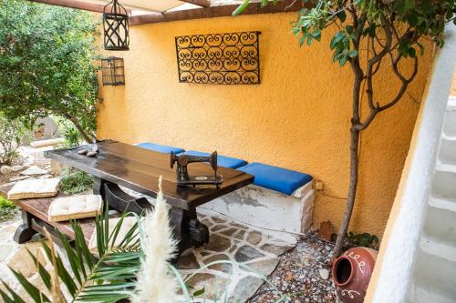 a table and bench in a patio with a fountain at Vagia Traditional, Aegina Island in Vaia