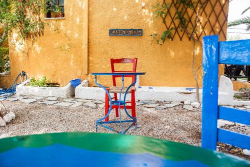 a red and blue table and chair in front of a building at Vagia Traditional, Aegina Island in Vaia