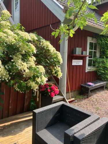 a black wicker bench in front of a red building at Lilla lägenheten in Broddetorp