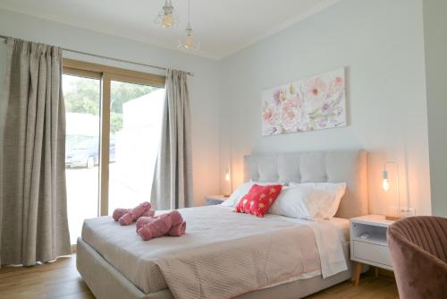 a bedroom with a bed with a teddy bear on it at Villa Michalis in Liapades