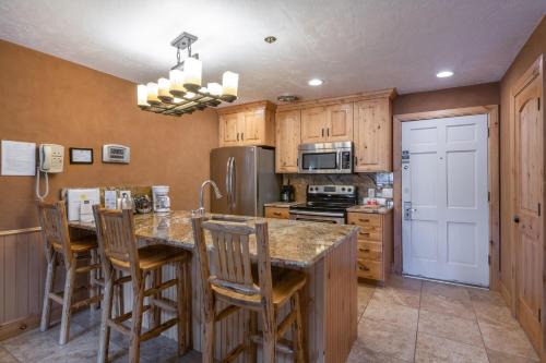 a kitchen with wooden cabinets and a island with bar stools at Treasure Mountain Inn in Park City