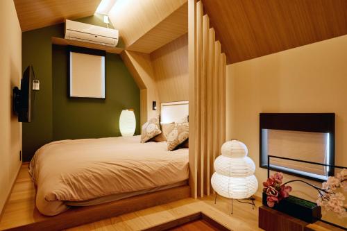 1 dormitorio con 1 cama con pared verde en LiveGRACE Mabuji Park Hotel - Vacation STAY 51973v, en Tokio